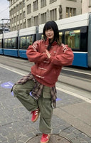 Person posing on a street with a tram in the background with cny jacket